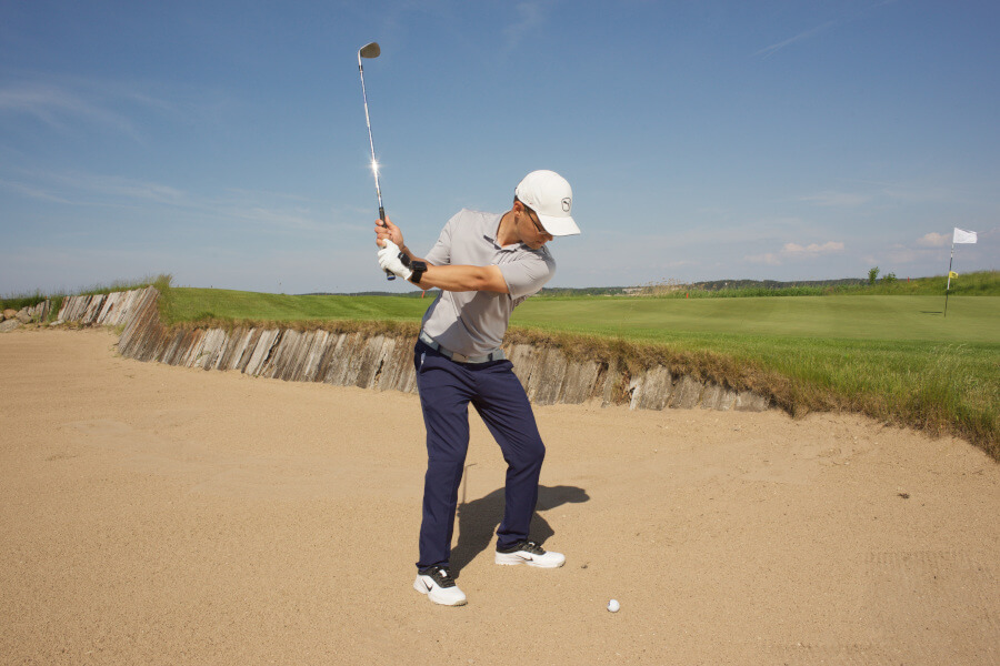 golf player trying to make bunker shot