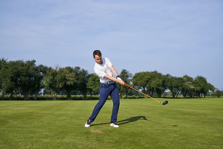 golfer hitting with driver on golf course