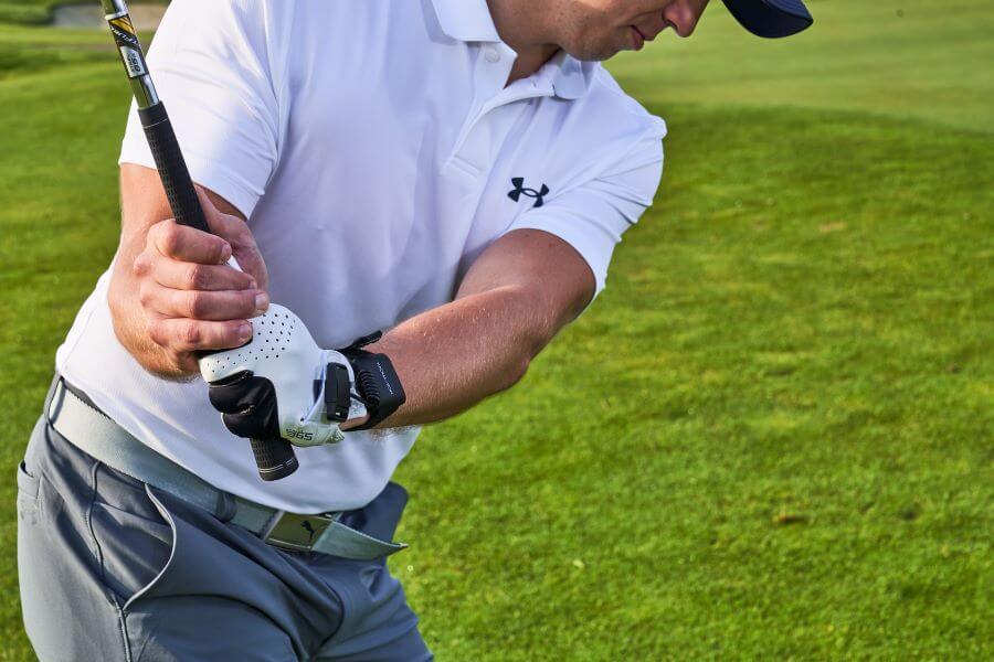 golfer on the golf course during downswing with iron